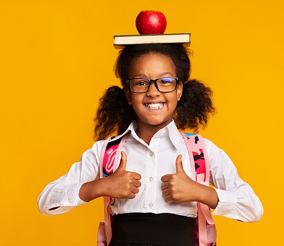 Girl wearing backpack with book and apple on head